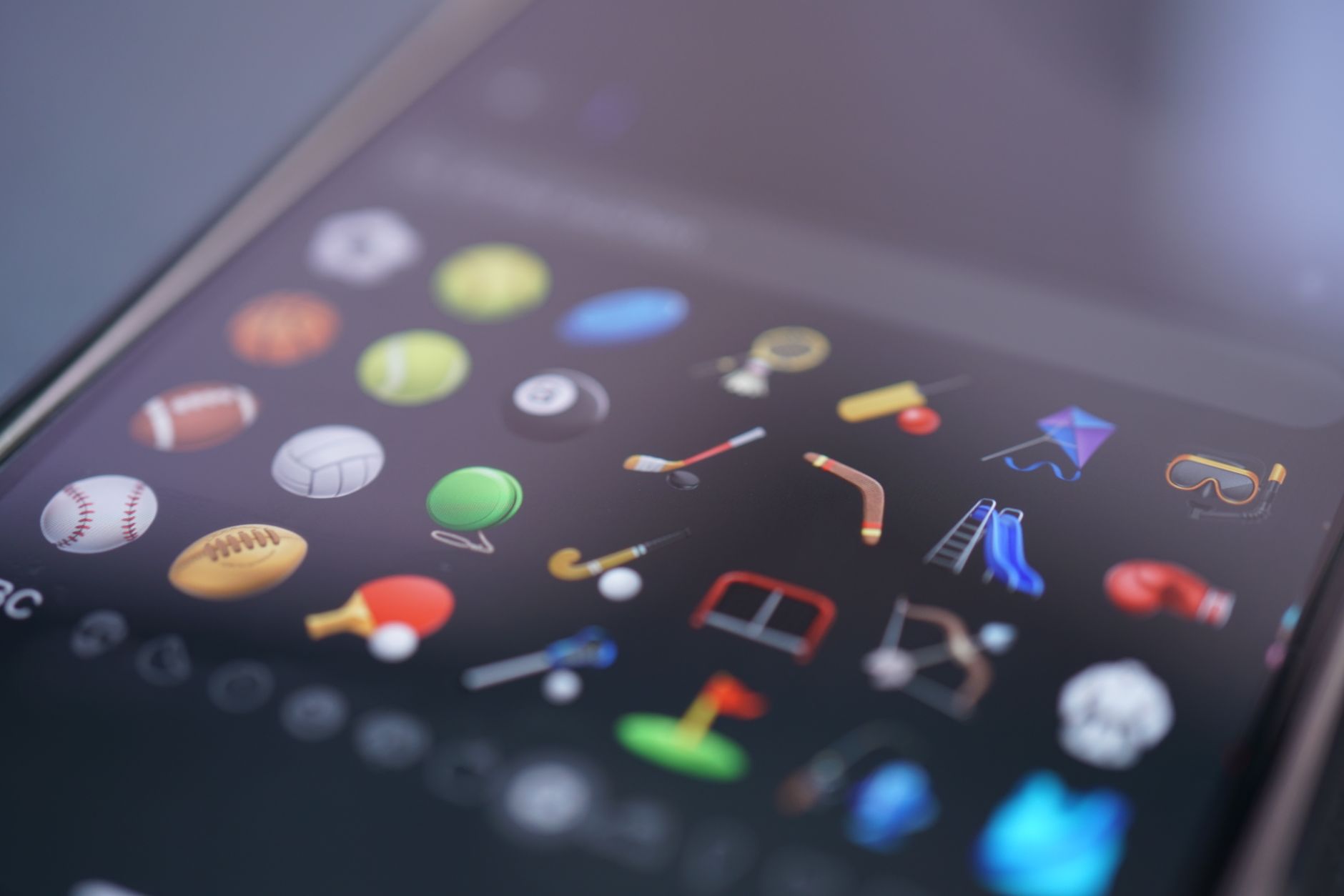 Close-up of various sports emojis displayed on a mobile device's screen